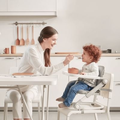 maman-nourrissant-bebe-dans-la-chaise-haute-bebe-confort-sylva-grise